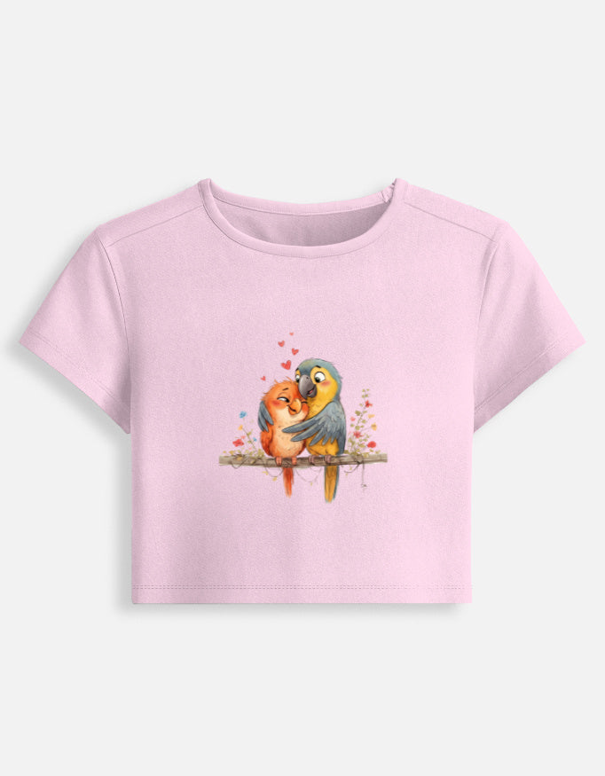 Women’s light pink fitted crop baby tee with colorful bird graphic on the front